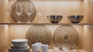 A wooden interior with woven baskets, metal bowls, and stacked plates. - LIV - Comfortable Athens Studio S8-2C (Athens)