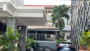 A modern building with a geometric facade, a car parked in front, and a pathway leading to the entrance. - SIX DIAMOND HOTEL OPEBI (Lagos)