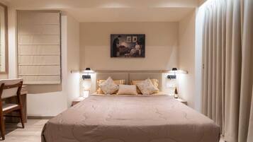 Una camera da letto con un letto grande, due comodini con lampade, una sedia e un quadro appeso al muro.