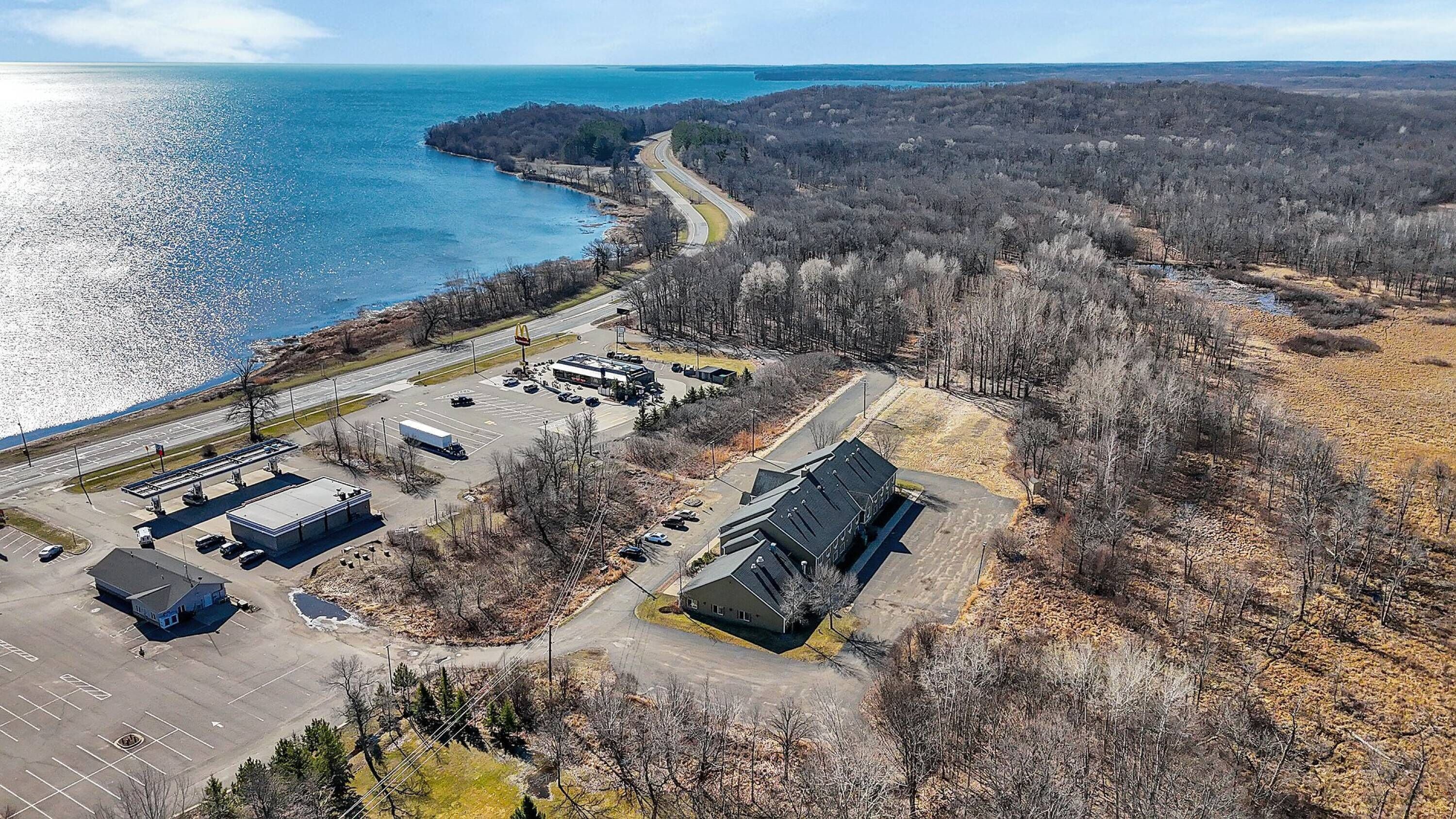 Une vue aérienne d’une zone côtière comprenant un parking, un bâtiment et une route.