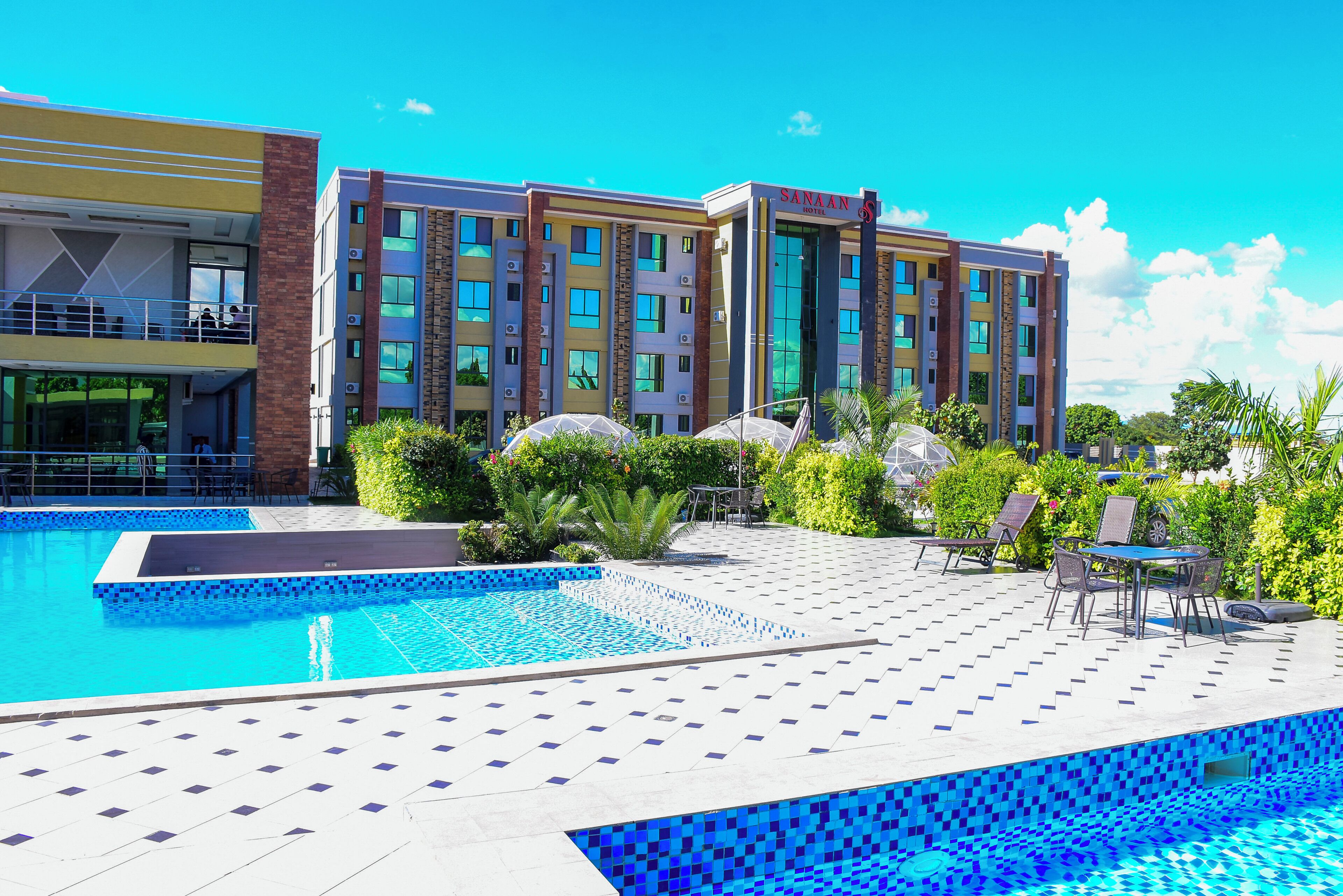 Ein Hotel mit Schwimmbad, Außenbereich und blauem Himmel.