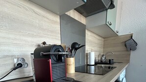 Una cocina moderna con encimera de madera, una cafetera, un hervidor y un lavabo.