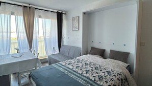 Un dormitorio con una cama, un escritorio y una silla.