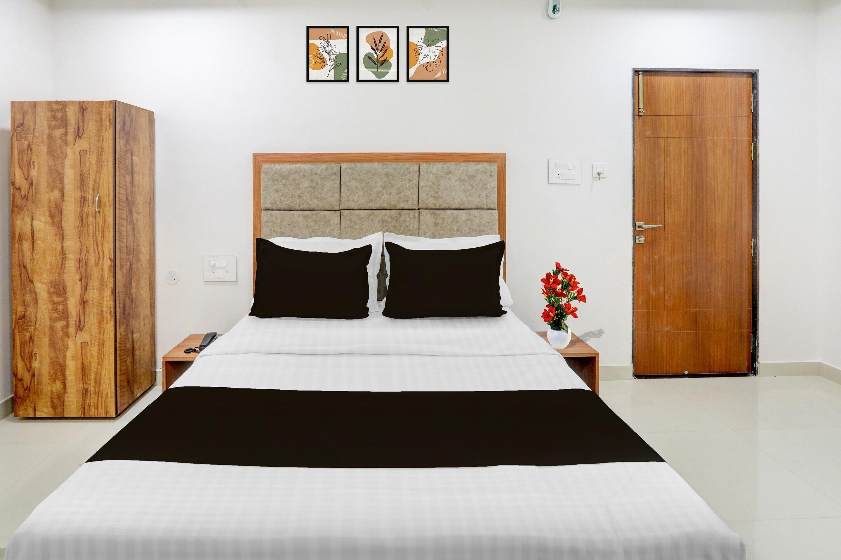 Una camera da letto con un letto, un'armadio in legno, un comodino e una porta.
