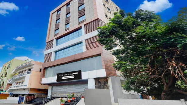 A multi-story building with a sign for 'TOWNHOUSE OAK' and a staircase leading to the entrance. - Super Townhouse Oak Garden (Hanmakonda)