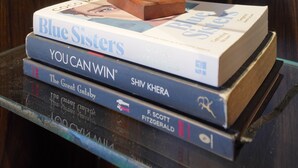 A stack of books with a decorative object on top.