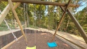 Puinen keinuteline metsäisellä alueella, jonka alla on maaperä.