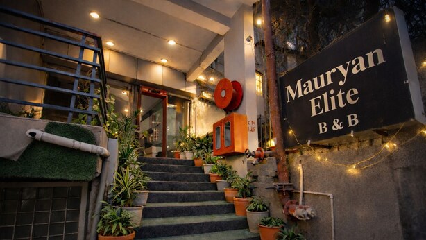 Una escalera que lleva a un edificio con un letrero que dice 'Mauryan Elite B&B'.
