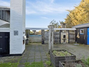 A courtyard with a brick oven, a blue door, and a sign reading 'THALATTA'. - 4 Star Holiday Home in Lokken (Lokken)