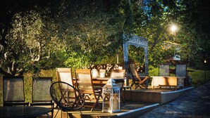 Outdoor seating with chairs and tables, a lantern, and a decorative archway. - TENUTA LISETTA (Monterotondo)