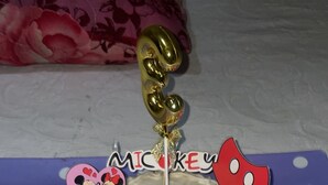 A cake with Mickey Mouse decorations and a 'MICKEY' topper.