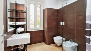 Ein Badezimmer mit Waschbecken, Bidet, Spiegel und Handtuchhalter.