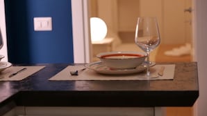 Eine Küchenarbeitsplatte mit Schüssel, Weinglas und Besteck auf einer Matte.