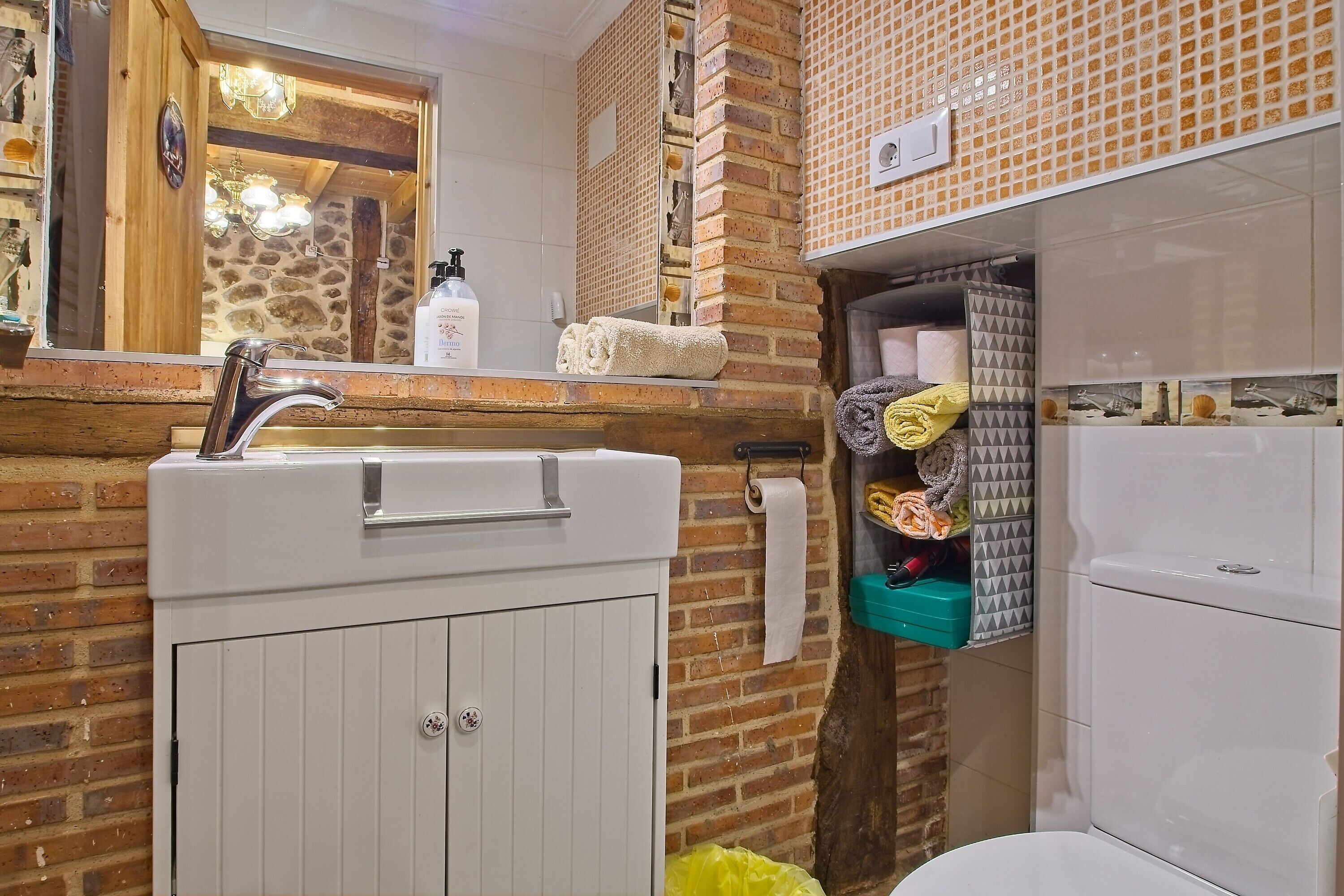 A bathroom with a white sink, a mirror, a towel rack, and a toilet.
