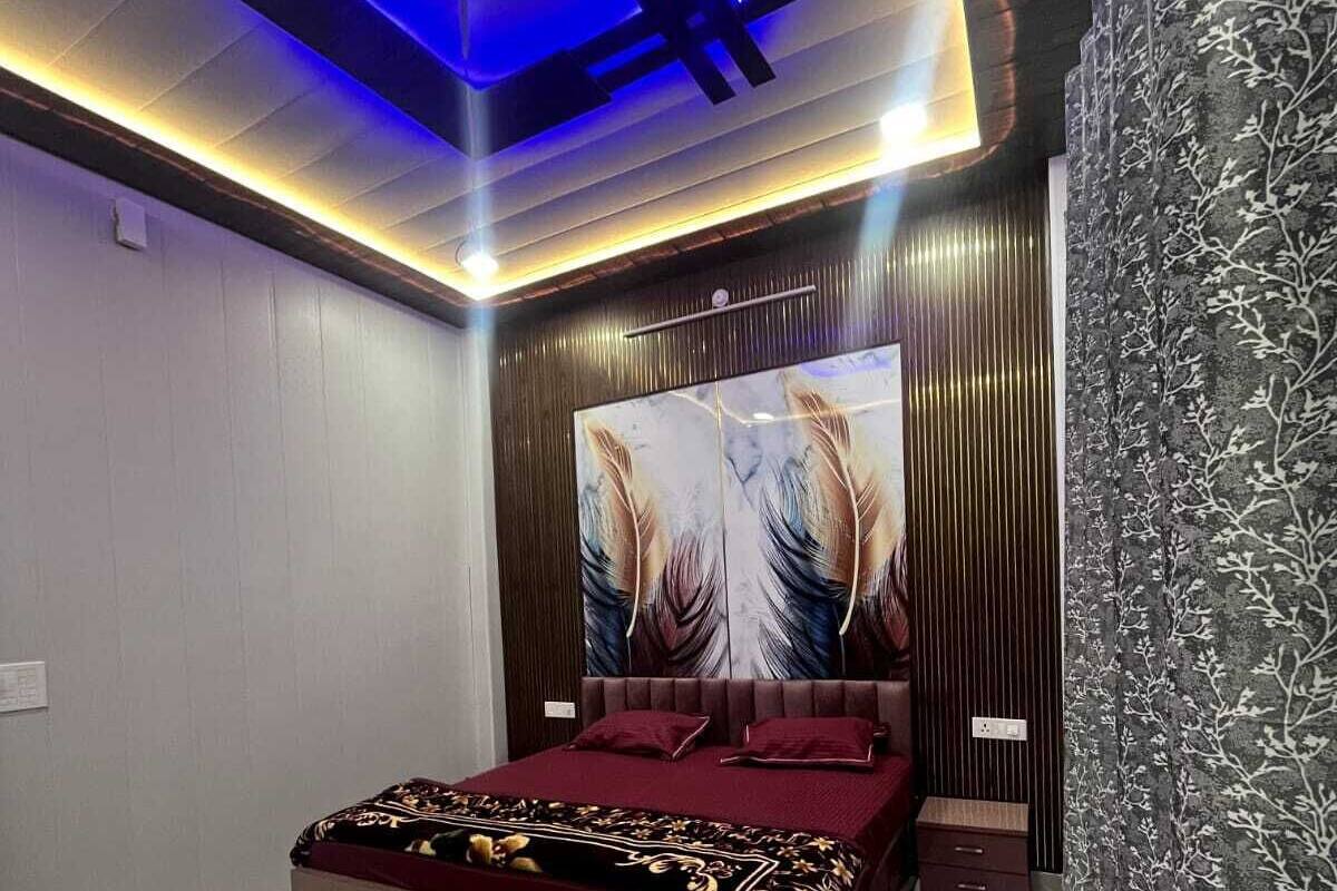 Un dormitorio moderno con una cama grande, una lámpara de techo e una obra de arte colgada en la pared.