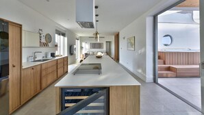 Una cucina moderna con isola centrale, mobili in legno e vista su una terrazza esterna.
