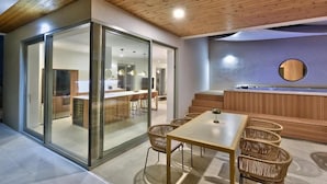 Un interno moderno con soffitto in legno, una parete divisoria in vetro, una scrivania della reception e poltrone in vimini.