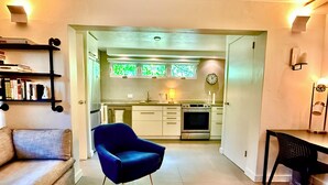 Una cocina moderna con comedor, sofá y una silla azul.