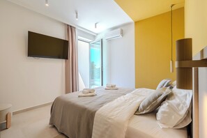 A modern hotel room with a bed, a flat-screen TV, an air conditioning unit, and a view of the outdoors. - Villa Axi by old Town (Sibenik)