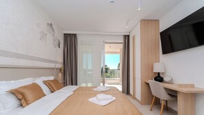 A hotel room with a bed, a desk, a TV, and a view of the outdoors. - Villa Nexi by old Town (Sibenik)