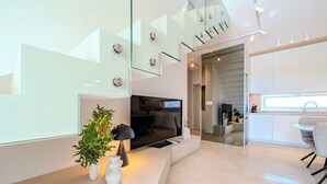 A modern living room with a TV, a plant, and a dining area with a table and chairs. - Villa Nexi by old Town (Sibenik)