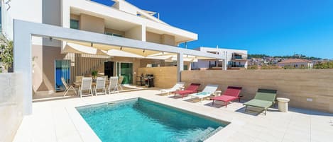 Outdoor pool, a heated pool, open open 24 hours a day, pool umbrellas