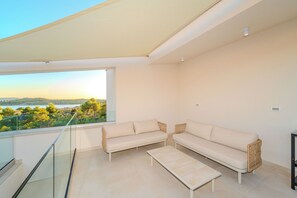 A balcony with two sofas and a table, overlooking a scenic landscape. - Villa Nexi by old Town (Sibenik)