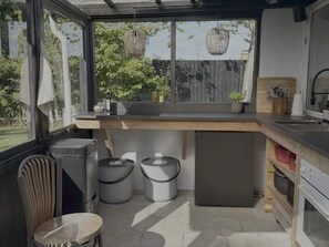A kitchen with a built-in sink, wooden countertop, and a view of greenery outside. - 4 Star Holiday Home in Follenslev (Follenslev)
