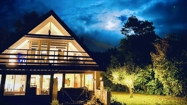 Ein Haus mit einem dreieckigen Dach, großen Fenstern und einem hellen Innenraum.