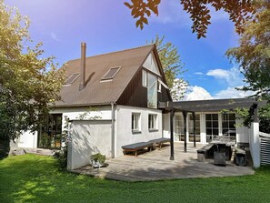 A two-story house with a wooden deck, a pergola, and a barbecue area. - 4 Star Holiday Home in Follenslev (Follenslev)