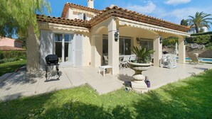 Una casa con un patio, muebles de exterior y una piscina.