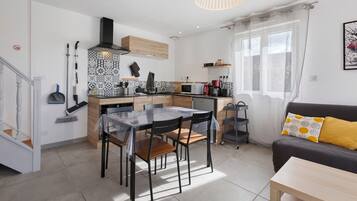 Una cocina moderna con zona de comedor, sofá y ventana con cortinas.
