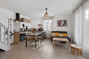 Una cocina moderna con comedor, un sofá y una mesa pequeña.