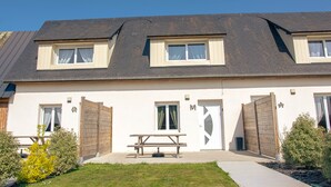 A two-story building with a flat roof, a front door, and a picnic table in the front yard. - 2-Star Holiday Home “Le Mascaret des Abbayes du Val de Seine” (Sainte-Marguerite-sur-Duclair)
