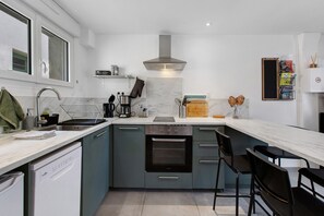 Una cocina moderna con horno integrado, cafetera y lavamanos.