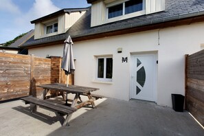 Una casa con un patio, una valla de madera y una puerta con ventana.