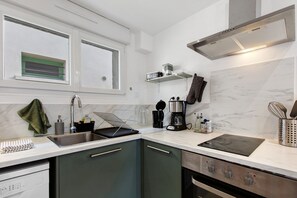 A modern kitchen with a sink, stove, and countertop appliances. - 2-Star Holiday Home “Le Mascaret des Abbayes du Val de Seine” (Sainte-Marguerite-sur-Duclair)