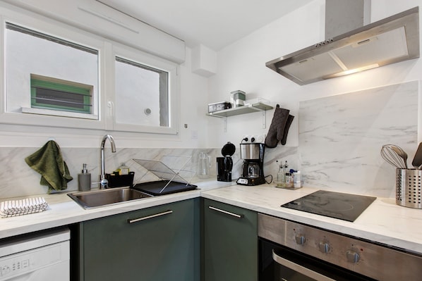 Una cocina moderna con un lavabo, estufa y electrodomésticos en la encimera.