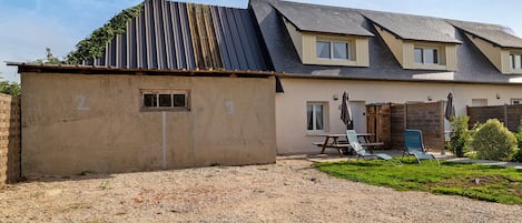 Una casa de dos pisos con camino de grava y patio trasero cercado.