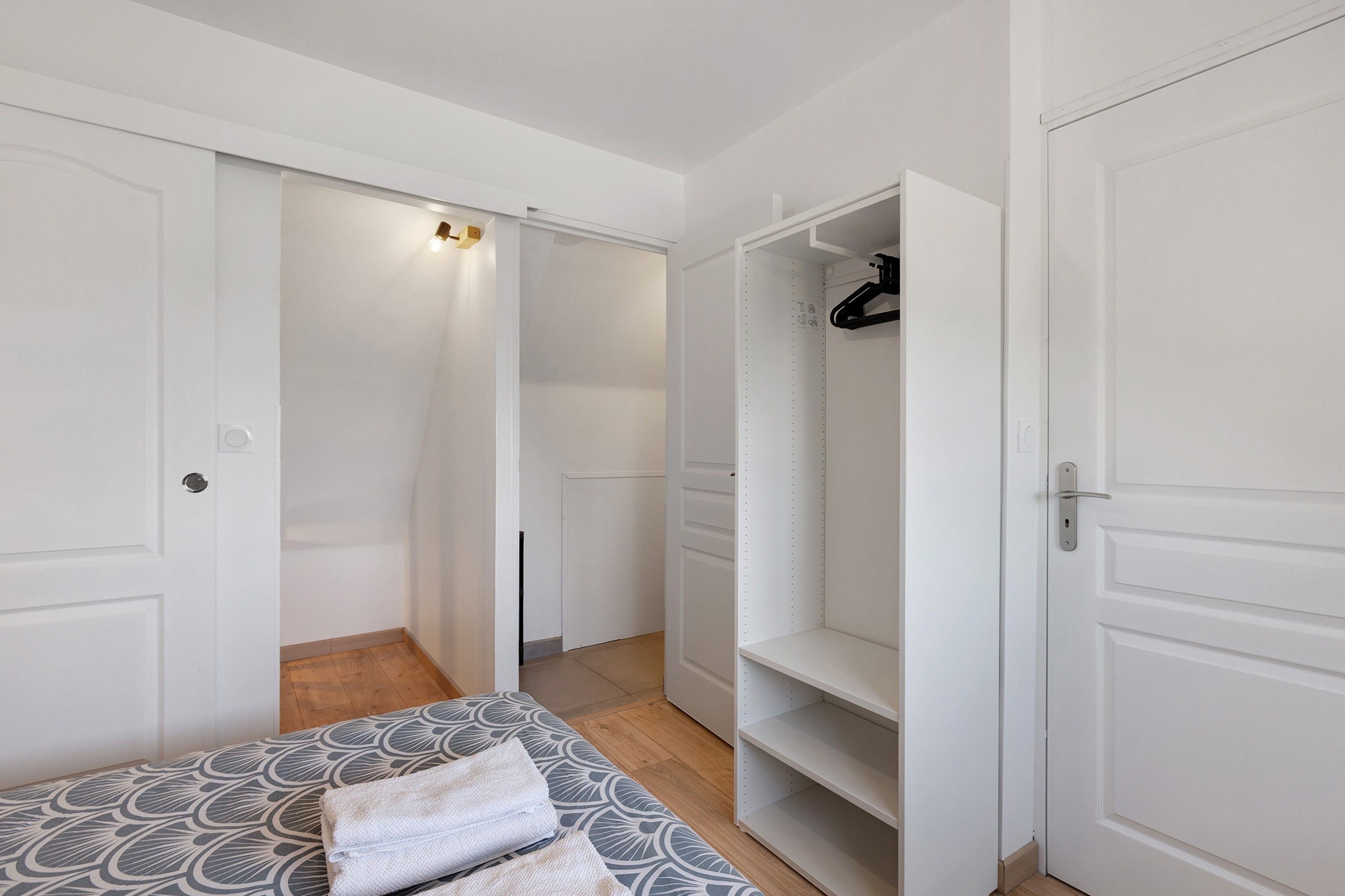 Une chambre à coucher avec un lit, une armoire et un placard.