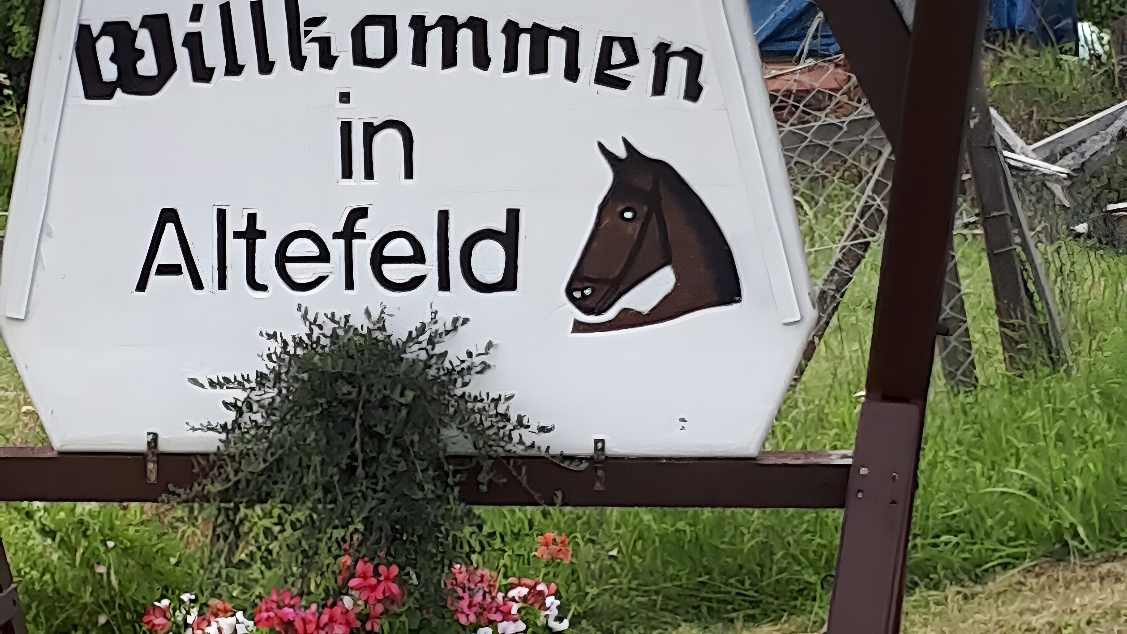 A welcome sign with a horse's head and the text 'Willkommen in Altefeld.'