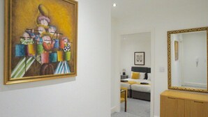 Habitación de hotel con cama, mesita de noche y un espejo grande con marco dorado.