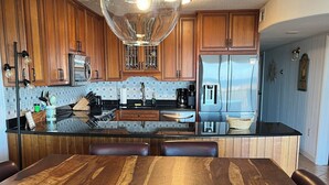Una cocina moderna con armarios de madera, una isla central y una mesa de comedor.