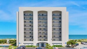 Un hotel de varios pisos con balcones, piscina y vista a la playa.
