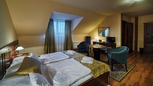 Une chambre d’hôtel avec un lit, un bureau, une chaise et un téléviseur.