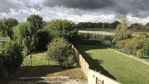 A grassy area with a concrete pathway and a metal fence. - Countryside Stay With Terrace (Heers)