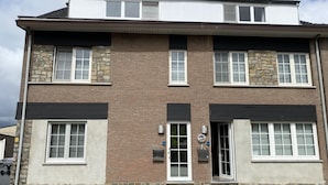 A two-story building with a brick facade, large windows, and a flat roof. - Countryside Stay With Terrace (Heers)