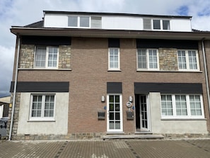 Ein zweistöckiges Gebäude mit Ziegelverkleidung, großen Fenstern und einem Flachdach.