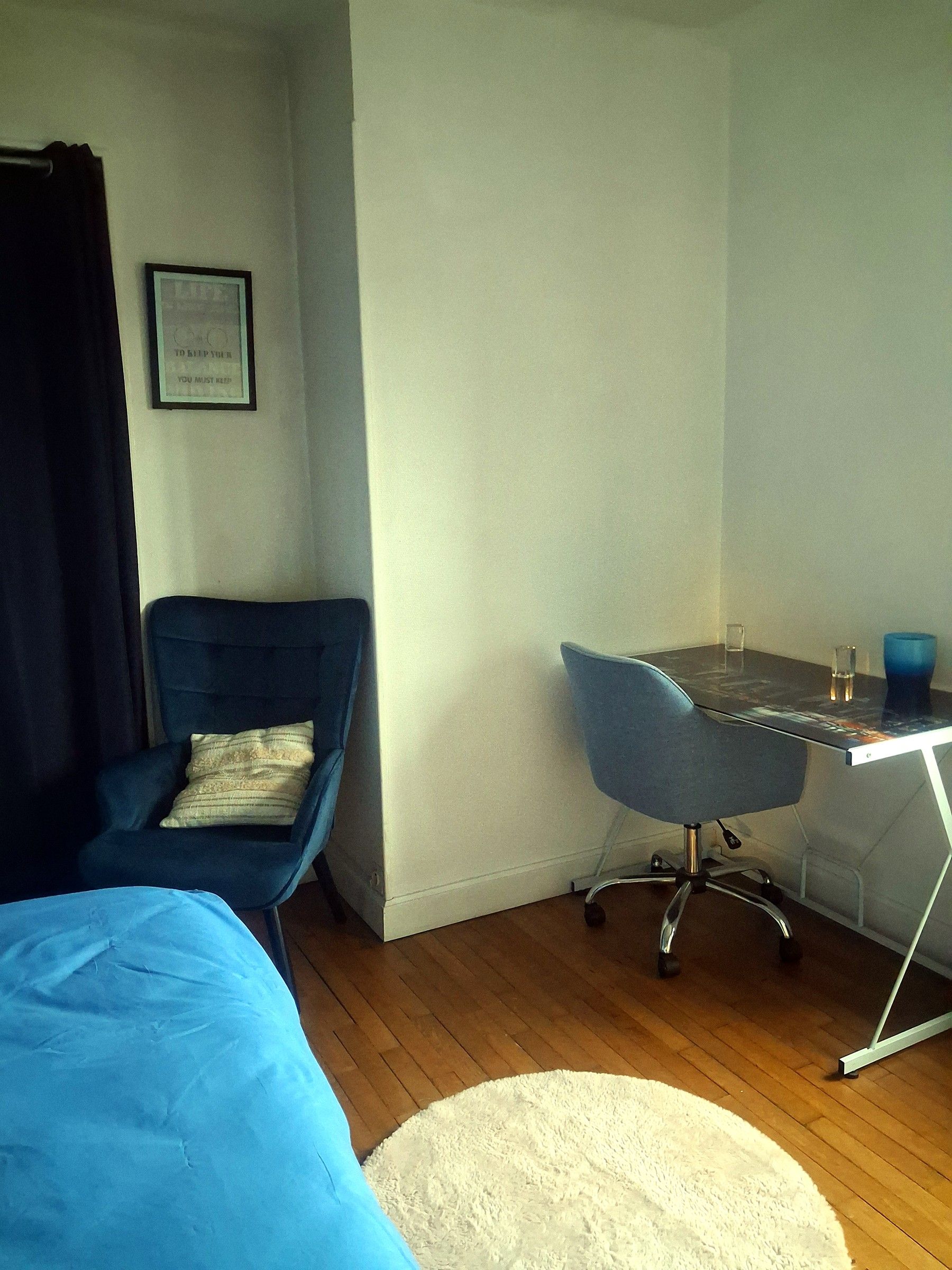 Une chambre à coucher avec un lit, une chaise, un bureau et un tapis.