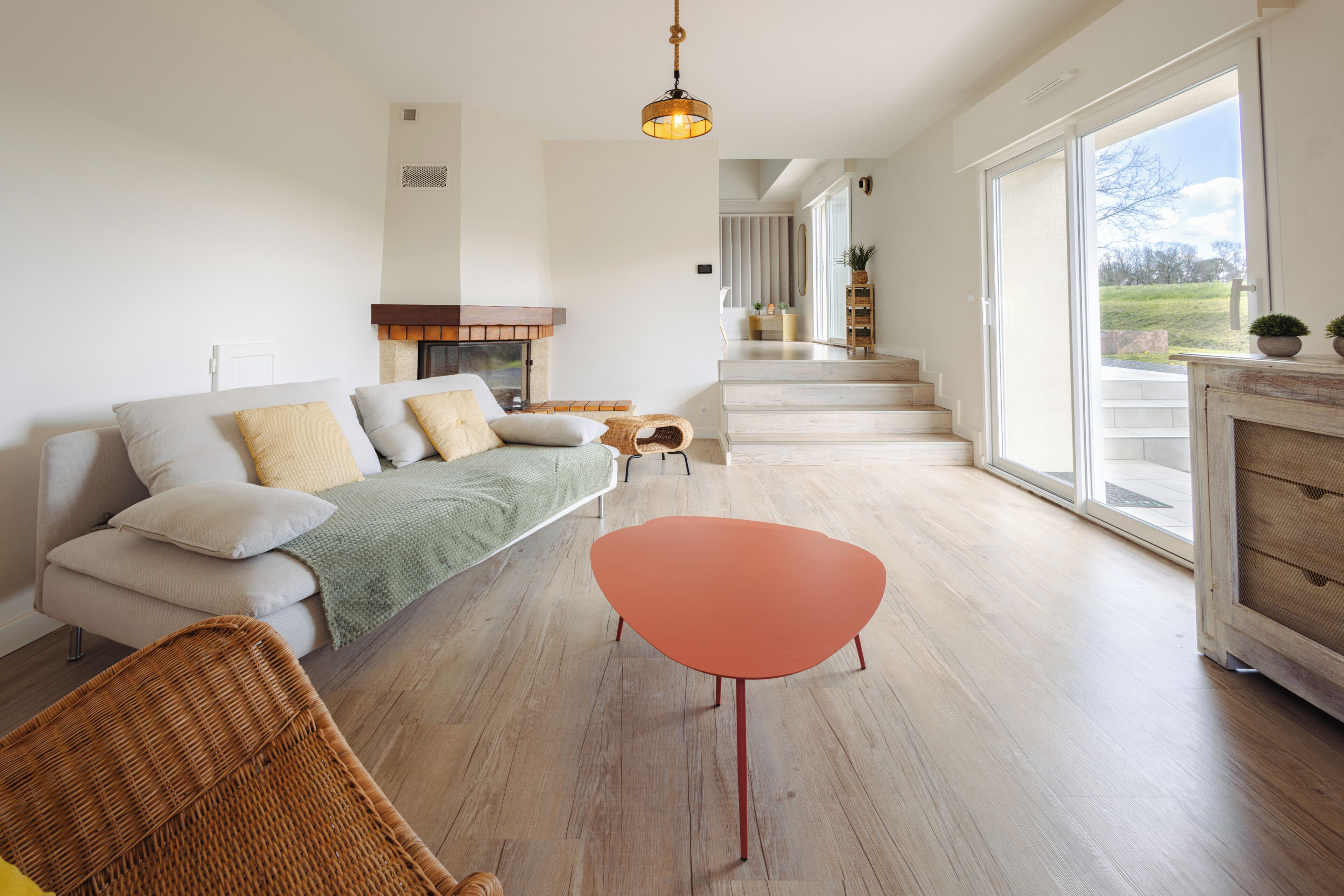 A spacious living room with a sofa, a small table, and a fireplace.